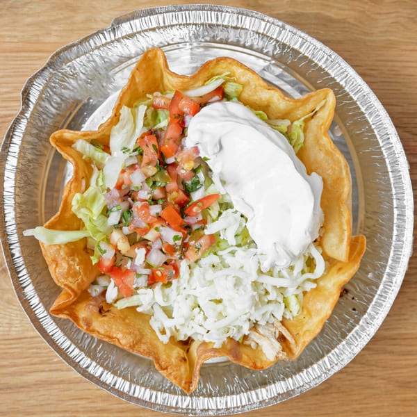 Chido's Tacos taco salad in a crispy fried shell with pico de gallo, cheese, and sour cream.
